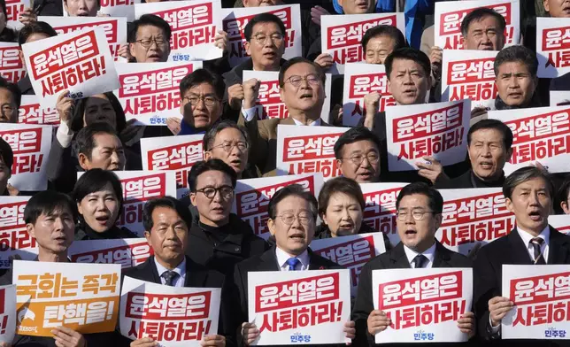 South Korea's main opposition Democratic Party leader Lee Jae-myung, bottom center, shout slogans during a rally against President Yoon Suk Yeol at the National Assembly in Seoul, South Korea, Wednesday, Dec. 4, 2024. The signs read "Yoon Suk Yeol should resign." (AP Photo/Ahn Young-joon)