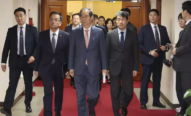 South Korean Prime Minister Han Duck-soo, center, and other ministers leave after a meeting at the government complex in Seoul, South Korea, Wednesday, Dec. 4, 2024. (Choi Jae-gu/Yonhap via AP)