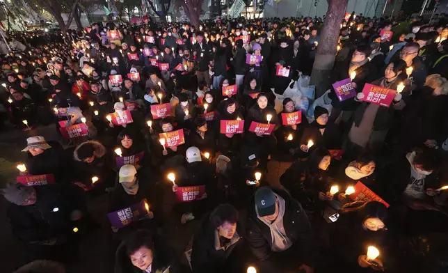 People hold candles during a candlelight vigil against South Korean President Yoon Suk Yeol in Seoul, South Korea, Wednesday, Dec. 4, 2024. (AP Photo/Lee Jin-man)