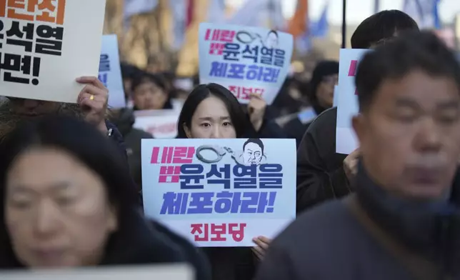 South Koreans hold signs reading "Arrest Yoon Suk Yeol" during a rally in Seoul, South Korea, Wednesday, Dec. 4, 2024. (AP Photo/Lee Jin-man)