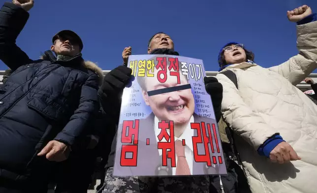 Members of main opposition Democratic Party shout slogans during a rally against South Korean President Yoon Suk Yeol at the National Assembly in Seoul, South Korea, Wednesday, Dec. 4, 2024. The signs read "Stop." (AP Photo/Ahn Young-joon)