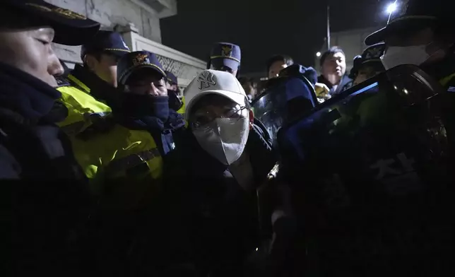 People try to enter as police officers stand guard in front of the National Assembly in Seoul, South Korea, Tuesday, Dec. 3, 2024. (AP Photo/Lee Jin-man)