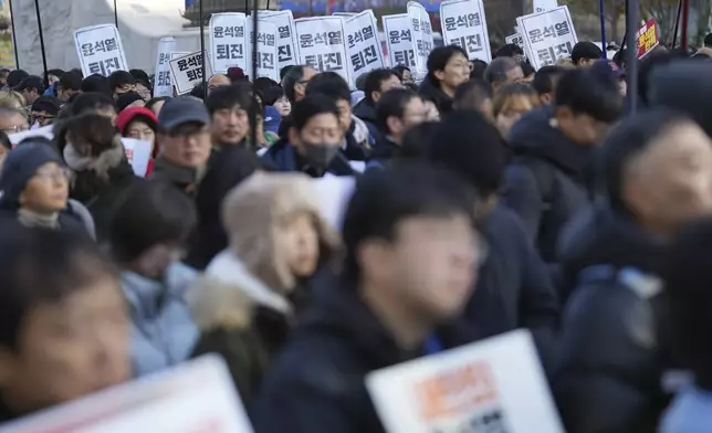 South Koreans hold signs reading "Resign Yoon Suk Yeol" during a rally in Seoul, South Korea, Wednesday, Dec. 4, 2024. (AP Photo/Lee Jin-man)