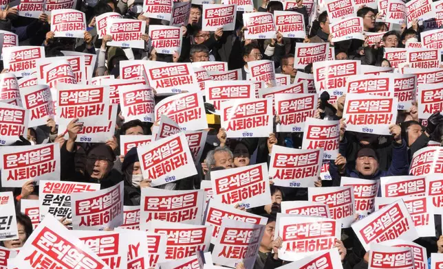 Members of main opposition Democratic Party stage a rally against South Korean President Yoon Suk Yeol at the National Assembly in Seoul, South Korea, Wednesday, Dec. 4, 2024. The signs read "Yoon Suk Yeol should resign." (AP Photo/Ahn Young-joon)