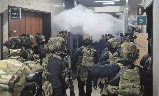 National Assembly employees spray a fire extinguisher towards soldiers at the National Assembly in Seoul, South Korea, Wednesday, Dec. 4, 2024. (Cho Da-un/Yonhap via AP)