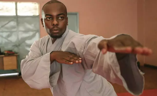 Evans Munzaa, 30 years, demonstrates a stance of praying mantis kung fu, a Chinese martial art, at a training school in Kabiria on the outskirts of Nairobi, Kenya Tuesday, Nov. 12, 2024. (AP Photo/Henry Naminde)