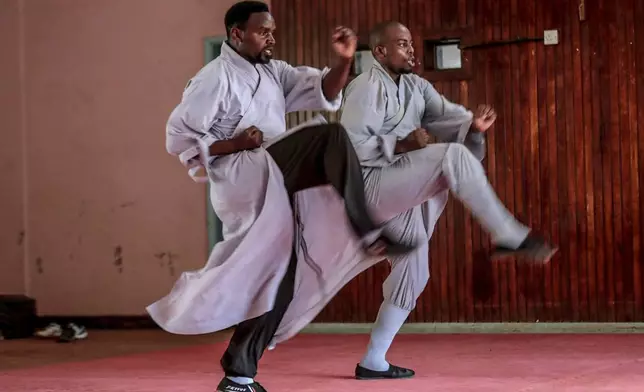 Evans Munzaa, 30 years, right, and his coach Kennedy Murimi demonstrate a stance of kung fu, a Chinese martial art, at a training school in Kabiria on the outskirts of Nairobi, Kenya Tuesday, Nov. 12, 2024. (AP Photo/Henry Naminde)