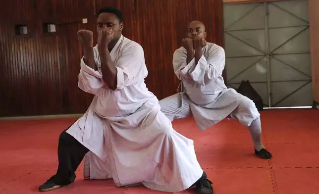 Evans Munzaa, 30 years, right, and his coach Kennedy Murimi demonstrate a stance of kung fu, a Chinese martial art, at a training school in Kabiria on the outskirts of Nairobi, Kenya Tuesday, Nov. 12, 2024. (AP Photo/Henry Naminde)
