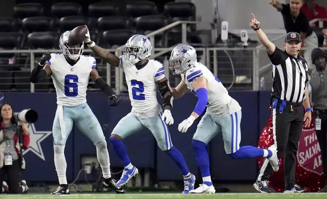 Dallas Cowboys cornerback Jourdan Lewis (2), Donovan Wilson (6) and Nick Vigil, right, celebrate Lewis' interception in t he second half of an NFL football game against the Tampa Bay Buccaneers in Arlington, Texas, Sunday, Dec. 22, 2024. (AP Photo/Julio Cortez)