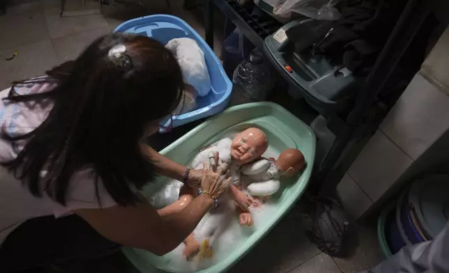 A volunteer washes recycled dolls to donate them to vulnerable children as Christmas presents, at the non-profit foundation Hospital de los Peluches, or Hospital of Stuffed Animals, in Caracas, Venezuela, Thursday, Dec. 5, 2024. (AP Photo/Ariana Cubillos)