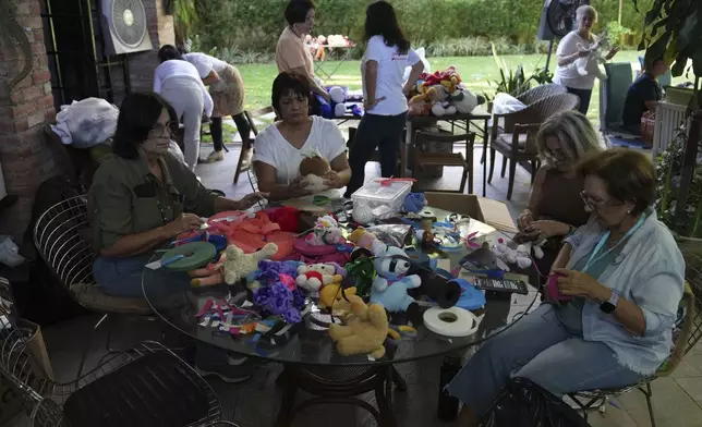 Volunteers restore used toys to donate them to vulnerable children as Christmas presents, at the non-profit foundation Hospital de los Peluches, or Hospital of Stuffed Animals, in Caracas, Venezuela, Thursday, Dec. 5, 2024. (AP Photo/Ariana Cubillos)
