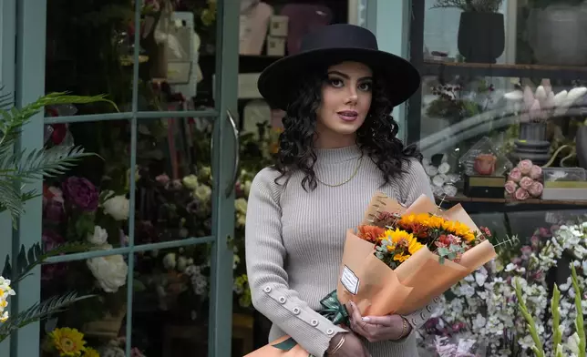 An Iranian woman, without wearing her mandatory Islamic headscarf, leaves a flower shop in port city of Bandar Anzali in northern Iran, Thursday, Dec. 5, 2024. (AP Photo/Vahid Salemi)