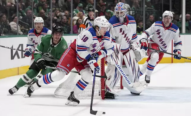 New York Rangers left wing Artemi Panarin (10) controls the puck in front of Dallas Stars' Mason Marchment (27) in the first period of an NHL hockey game in Dallas, Friday, Dec. 20, 2024. (AP Photo/Tony Gutierrez)