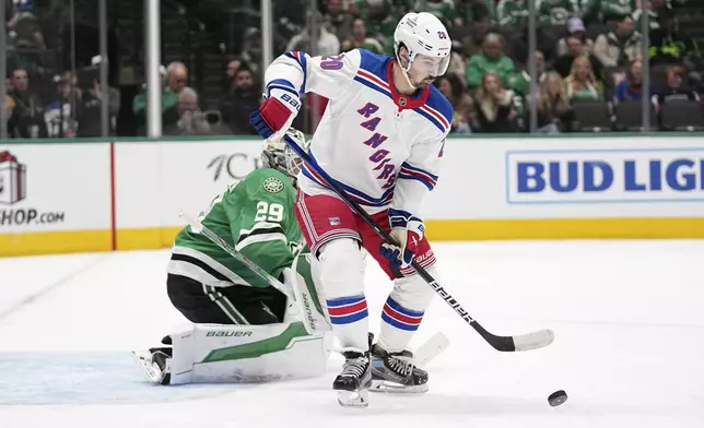 New York Rangers left wing Chris Kreider (20) pressures the net as Dallas Stars goaltender Jake Oettinger (29) defends in the second period of an NHL hockey game in Dallas, Friday, Dec. 20, 2024. (AP Photo/Tony Gutierrez)