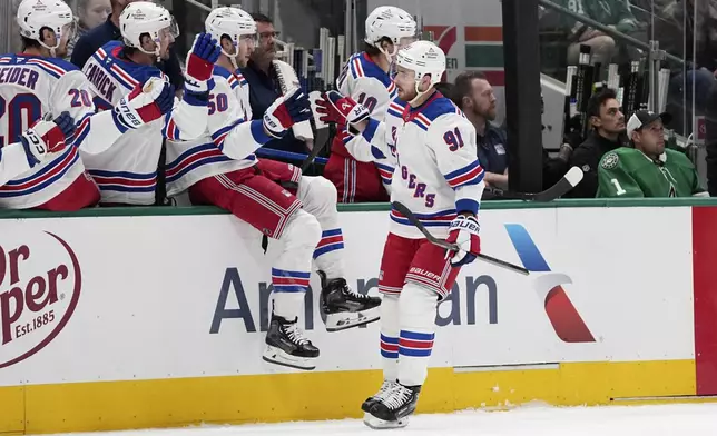 New York Rangers right wing Reilly Smith (91) celebrates with the bench after scoring against the Dallas Stars in the first period of an NHL hockey game in Dallas, Friday, Dec. 20, 2024. (AP Photo/Tony Gutierrez)