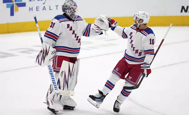 New York Rangers' Igor Shesterkin (31) and Vincent Trocheck (16) celebrate the team's win in an NHL hockey game against the Dallas Stars in Dallas, Friday, Dec. 20, 2024. (AP Photo/Tony Gutierrez)