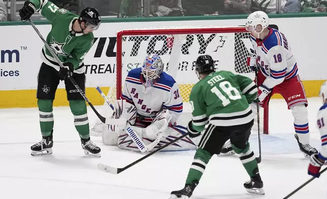 New York Rangers goaltender Igor Shesterkin (31) blocks a shot under pressure frojm Dallas Stars' Mason Marchment (27) and Sam Steel (18) as Urho Vaakanainen, right, looks on in the third period of an NHL hockey game in Dallas, Friday, Dec. 20, 2024. (AP Photo/Tony Gutierrez)