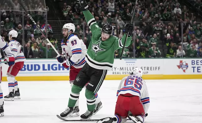 Dallas Stars center Roope Hintz (24) celebrates in front of New York Rangers' Brett Berard (65) and Mika Zibanejad (93) after Hintz scored in the first period of an NHL hockey game in Dallas, Friday, Dec. 20, 2024. (AP Photo/Tony Gutierrez)