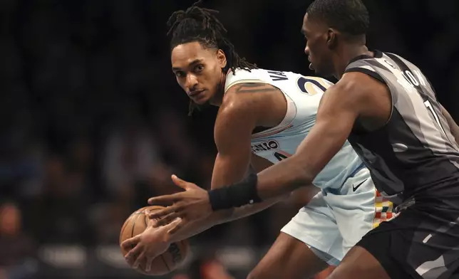 San Antonio Spurs' Devin Vassell, left, defends the ball from Brooklyn Nets' Shake Milton, right, during the second half of an NBA basketball game Friday, Dec. 27, 2024, in New York. (AP Photo/Pamela Smith)