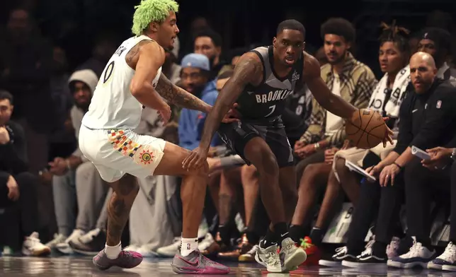 Brooklyn Nets' Shake Milton, right, dribbles the ball against San Antonio Spurs' Jeremy Sochan, left, during the second half of an NBA basketball game Friday, Dec. 27, 2024, in New York. (AP Photo/Pamela Smith)