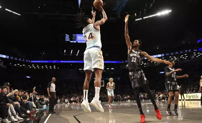 San Antonio Spurs' Devin Vassell, left, shoots the ball against Brooklyn Nets' Nic Claxton, right, during the second half of an NBA basketball game Friday, Dec. 27, 2024, in New York. (AP Photo/Pamela Smith)