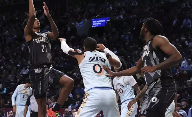 Brooklyn Nets' Noah Clowney, center, shoots the ball during the first half of an NBA basketball game against the San Antonio Spurs Friday, Dec. 27, 2024, in New York. (AP Photo/Pamela Smith)