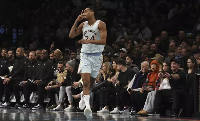 San Antonio Spurs' Devin Vassell, center, reacts after scoring a 3-point basket during the first half of an NBA basketball game against the Brooklyn Nets, Friday, Dec. 27, 2024, in New York. (AP Photo/Pamela Smith)