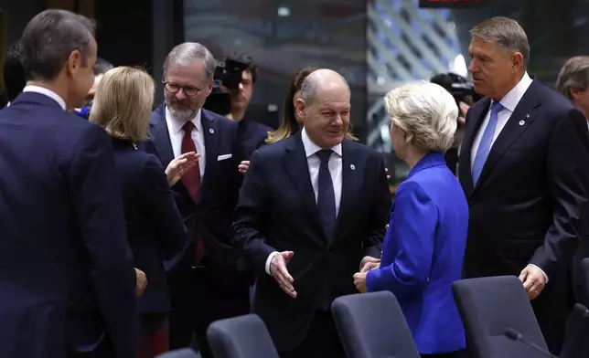 Germany's Chancellor Olaf Scholz, center, speaks with European Commission President Ursula von der Leyen during a round table meeting at an EU summit in Brussels, Thursday, Dec. 19, 2024. (AP Photo/Omar Havana)