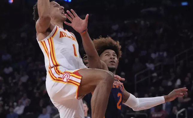 Atlanta Hawks' Jalen Johnson (1) drives past New York Knicks' Miles McBride (2) during the first half of an Emirates NBA Cup basketball game Wednesday, Dec. 11, 2024, in New York. (AP Photo/Frank Franklin II)