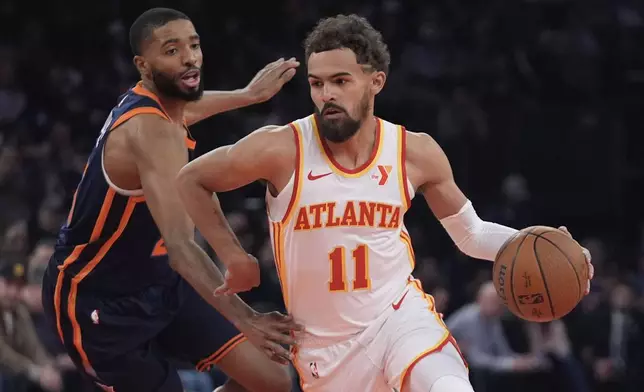 Atlanta Hawks' Trae Young (11) drives past New York Knicks' Mikal Bridges during the first half of an Emirates NBA Cup basketball game Wednesday, Dec. 11, 2024, in New York. (AP Photo/Frank Franklin II)