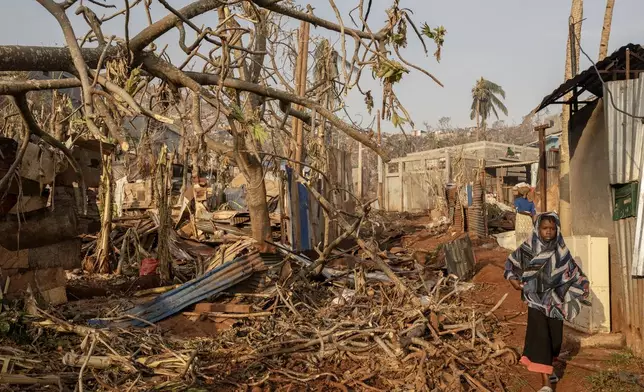 A girl walks amidst destruction in Mbouyougou, Mayotte, Saturday, Dec. 21, 2024. (AP Photo/Adrienne Surprenant)