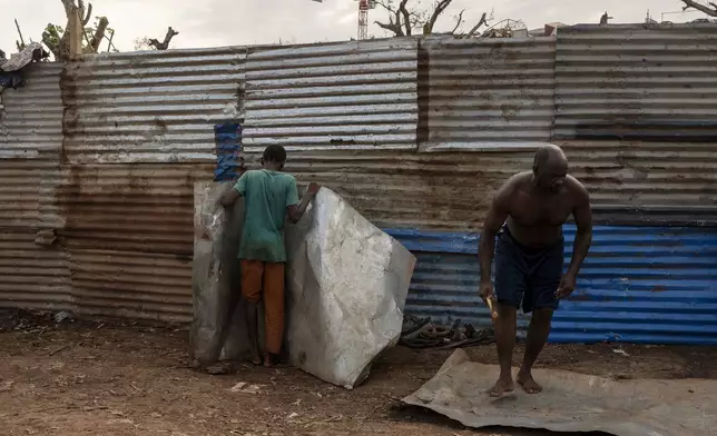 Resident repair their broken homes in Barakani, Mayotte, home Saturday, Dec. 21, 2024. (AP Photo/Adrienne Surprenant)