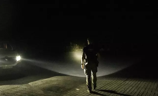 French gendarmes patrol during curfew outside Mamoudzou, Mayotte, Saturday, Dec. 21, 2024. (AP Photo/Adrienne Surprenant)