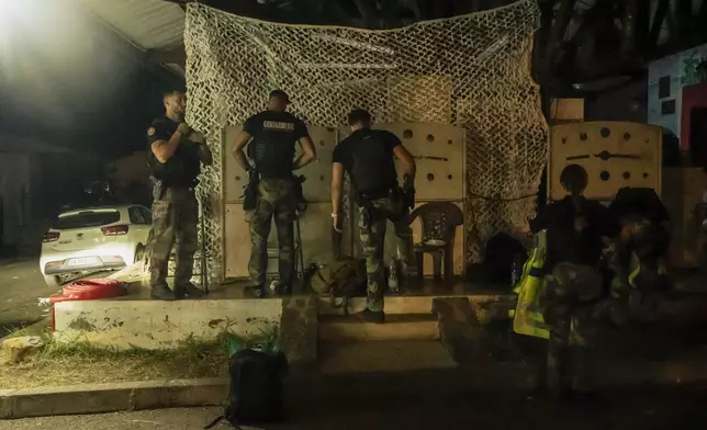 French gendarmes patrol during curfew outside Mamoudzou, Mayotte, Saturday, Dec. 21, 2024. (AP Photo/Adrienne Surprenant)