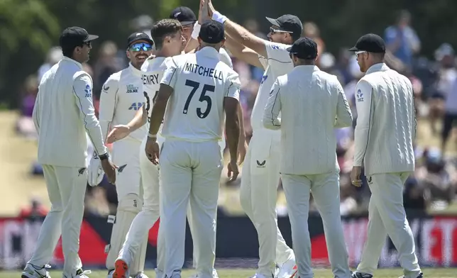 New Zealand players celebrate the dismissal of England's Zak Crawley during play on the fourth day of the first cricket test between England and New Zealand at Hagley Oval in Christchurch, New Zealand, Sunday, Dec. 1, 2024.(John Davidson/Photosport via AP)