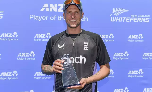 England's Brydon Carse poses with his-man-of-the-match trophy following England's eight wicket win over New Zealand in the first test at Hagley Oval in Christchurch, New Zealand, Sunday, Dec. 1, 2024.(John Davidson/Photosport via AP)