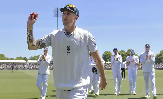 England's Brydon Carse gestures to the crowd after taking six wickets during play on the fourth day of the first cricket test between England and New Zealand at Hagley Oval in Christchurch, New Zealand, Sunday, Dec. 1, 2024.(John Davidson/Photosport via AP)