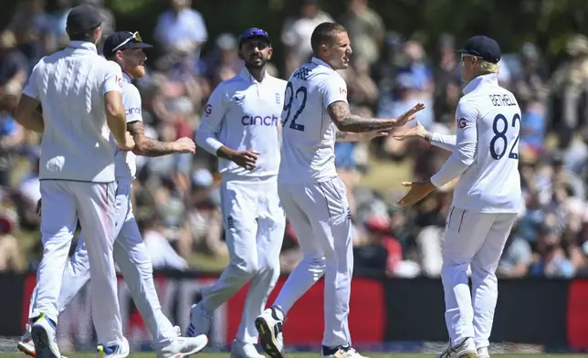 England players celebrate the wicket of New Zealand's Nathan Smith during play on the fourth day of the first cricket test between England and New Zealand at Hagley Oval in Christchurch, New Zealand, Sunday, Dec. 1, 2024.(John Davidson/Photosport via AP)