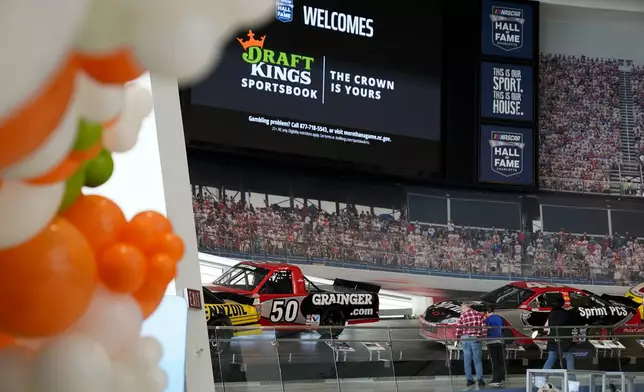 FILE - Guests tour the NASCAR Hall of Fame before the start of a DraftKings event celebrating the mobile and online sports wagering across North Carolina, March 11, 2024, in Charlotte, N.C. (AP Photo/Erik Verduzco, File)