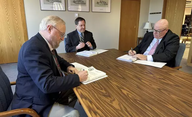 FILE - Cole County Circuit Judge Jon Beetem, from left, Missouri Secretary of State Jay Ashcroft and Cole County Circuit Judge Daniel Green review and sign the official results of the November election while meeting as the Board of State Canvassers, at Ashcroft's office in Jefferson City, Missouri, Thursday, Dec. 5, 2024. (AP Photo/David A. Lieb, File)