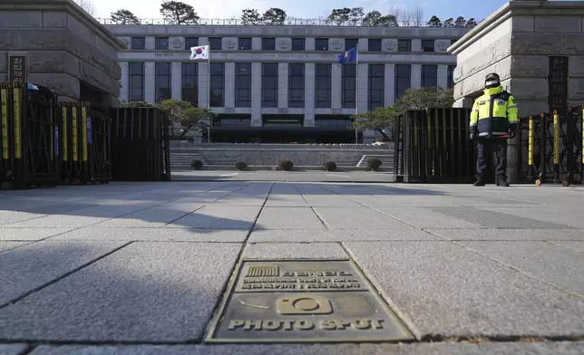 A South Korean police officer stands in front of the Constitutional Court in Seoul, South Korea, Tuesday, Dec. 17, 2024. (AP Photo/Lee Jin-man)