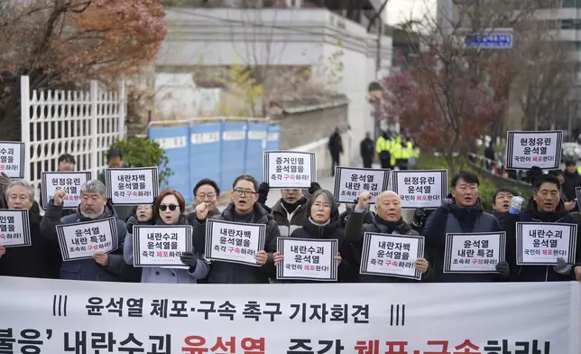 Members of civic groups shout slogans during a news conference demanding the arrest of President Yoon Suk Yeol near the presidential residence in Seoul, South Korea, Tuesday, Dec. 17, 2024. The letters read "Immediately arrest Yoon Suk Yeol." (AP Photo/Lee Jin-man)