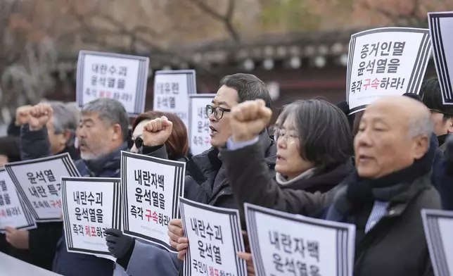 Members of civic groups shout slogans during a news conference demanding the arrest of President Yoon Suk Yeol near the presidential residence in Seoul, South Korea, Tuesday, Dec. 17, 2024. The letters read "Immediately arrest Yoon Suk Yeol." (AP Photo/Lee Jin-man)