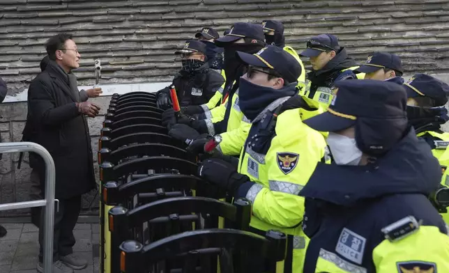 A member of civic groups is blocked by police offices after a news conference demanding the arrest of President Yoon Suk Yeol near the presidential residence in Seoul, South Korea, Tuesday, Dec. 17, 2024. (AP Photo/Lee Jin-man)