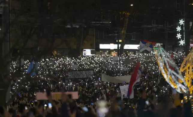 People use lights on their mobile phones during a protest against President Aleksandar Vucic and his government, in Belgrade, Serbia, Sunday, Dec. 22, 2024. (AP Photo/Marko Drobnjakovic)