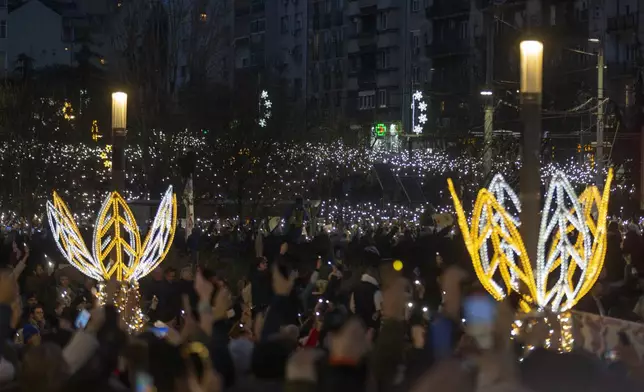 People use lights on their mobile phones during a protest against President Aleksandar Vucic and his government, in Belgrade, Serbia, Sunday, Dec. 22, 2024. (AP Photo/Marko Drobnjakovic)