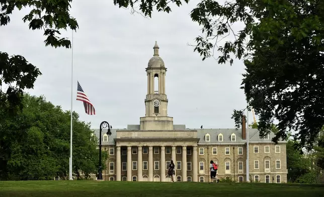 FILE - Pedestrians walk past Penn State University' Old Main building, Friday, May 15, 2015, in State College, Pa. (Nabil K. Mark/Centre Daily Times via AP)
