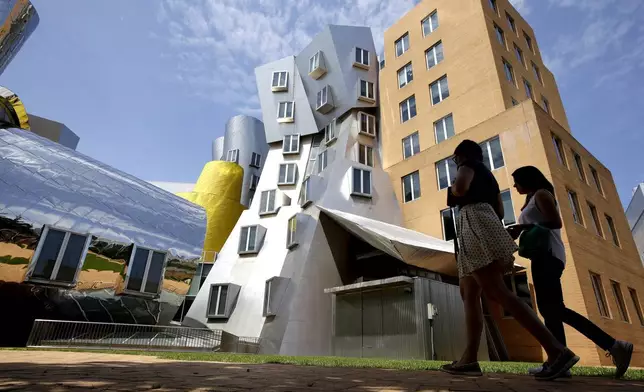 FILE - People walk past the Ray and Maria Stata Center on the campus of the Massachusetts Institute of Technology, in Cambridge, Mass., on July 16, 2019. (AP Photo/Steven Senne, File)