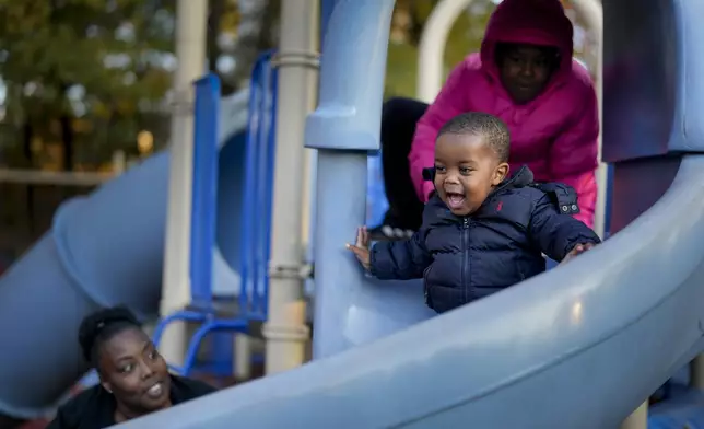 Anika Chillis, left, spends time with her children, Makhi, 2, center, and Myla 9, right, at a playground Monday, Dec. 2, 2024, in Memphis, Tenn. (AP Photo/George Walker IV)