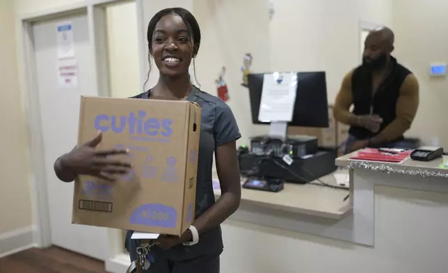 Tatayanna Johnson carries a box of diapers for her child from the Pharmalife Community Pharmacy, Monday, Dec. 9, 2024, in Murfreesboro, Tenn. Johnson participates in the states TennCare Diaper Benefit, which provides free diapers for children under the age of two. (AP Photo/George Walker IV)